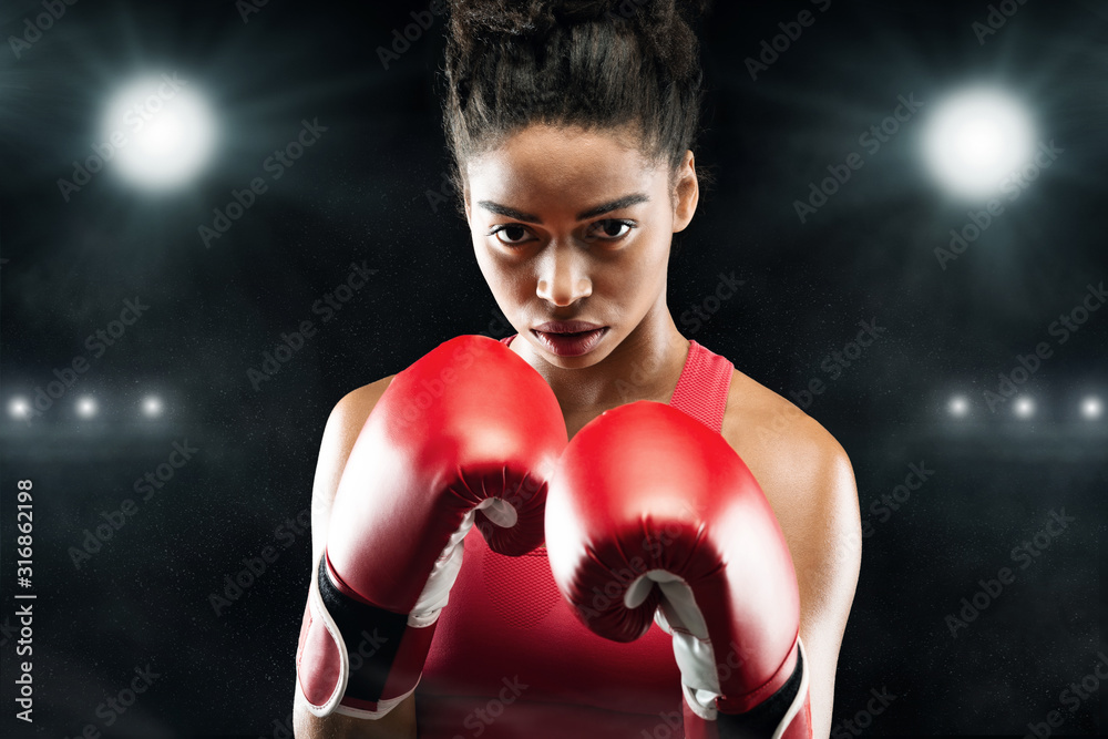 Confident black woman boxer standing in pose, ready to fight Confident black woman boxer standing in pose, ready to fight