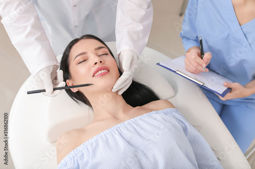 Plastic surgeon applying ma...