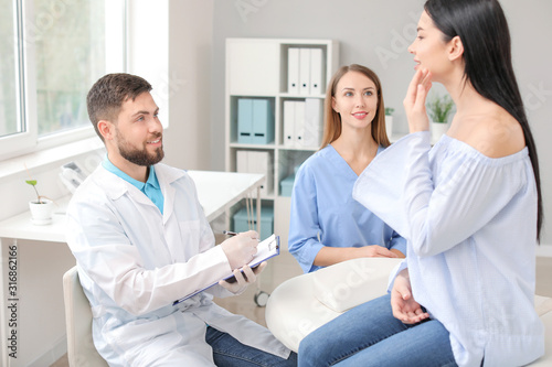 Beautiful woman meeting with plastic surgeon in clinic