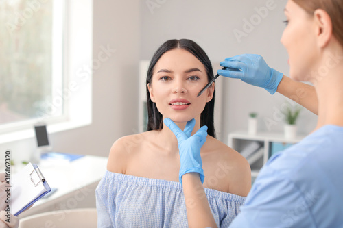 Plastic surgeon applying ma...