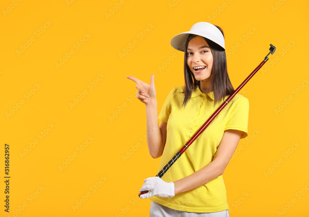 Beautiful female golfer pointing at something on color background - obrazy, fototapety, plakaty 