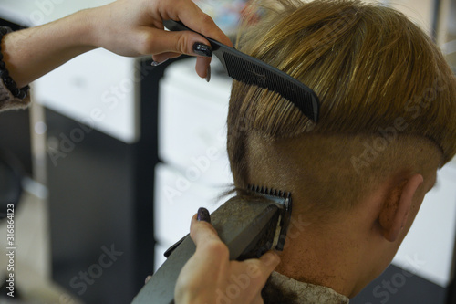 Hairdressing services. A man cuts hair at a hairdresser-stylist in a barbershop. scissors comb, clipper close-up.Barber at work. Close up cutting hair.