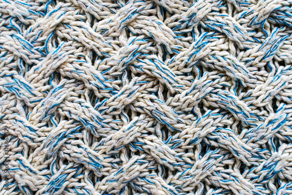 Blue and white texture of a knitted woolen fabric with a patterned weave. Sweater background Blue and white texture of a knitted woolen fabric with a patterned weave. Sweater background
