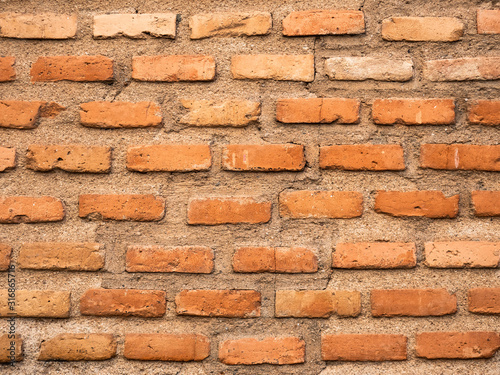 Brick wall made with bricks and with large gaps between their joints filled with cement