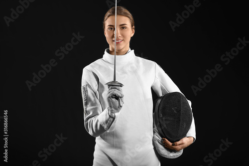 Young female fencer on dark background