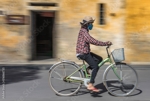 Panning motion shot of commuter in Hoi An, Vietnam.