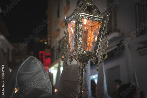 Nazarene in a procession at the holy week holding a candle