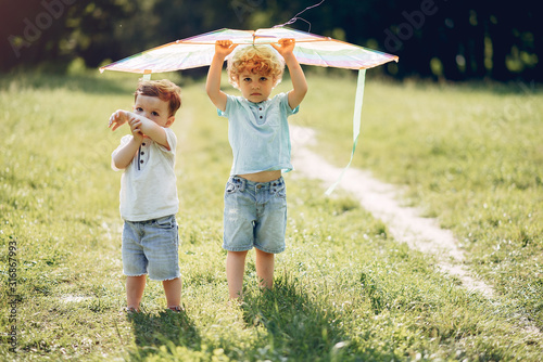 Little child in a summer field. Kids playing with a Kite photo