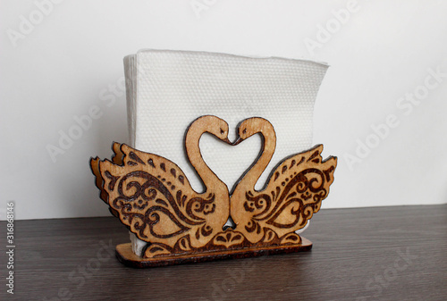 Handmade napkin holder, sawn in the shape of a pair of swans. Both swans are decorated with beautiful lines using pyrography.