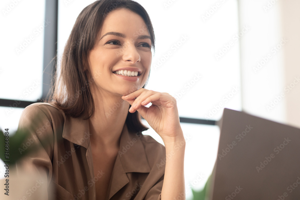 Portrait of smiling woman touching chin looking away Portrait of smiling woman touching chin looking away