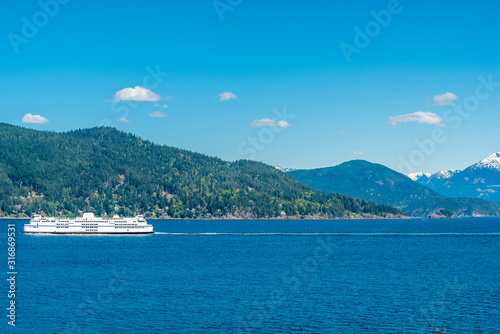 View over inlet, ocean and island with boat and mountains in beautiful British Columbia. Canada.