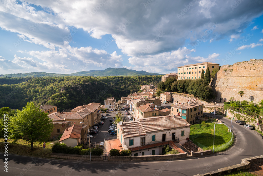 Panoramic view of small vilage in Italy with red brick houses and towers and nature in Sovana Sorano with beautiful sky with clouds in Lazio region Viterbo province in Italy