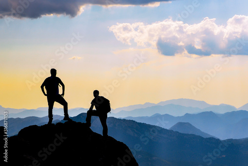 people watching the scenery from the summit and their proud, successful stances