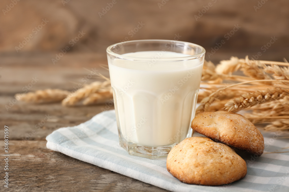 Glass of tasty milk with cookies on table Glass of tasty milk with cookies on table