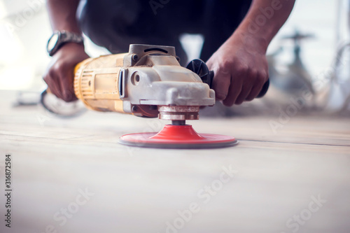 Handyman sanding floor. Repairs and renovation work photo