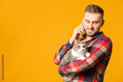 Man with cute cat talking b...