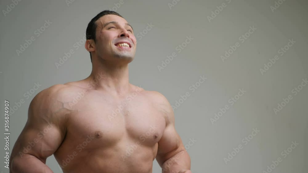 Young laughing muscular bodybuilder posing and looking at camera, isolated on white background Young laughing muscular bodybuilder posing and looking at camera, isolated on white background