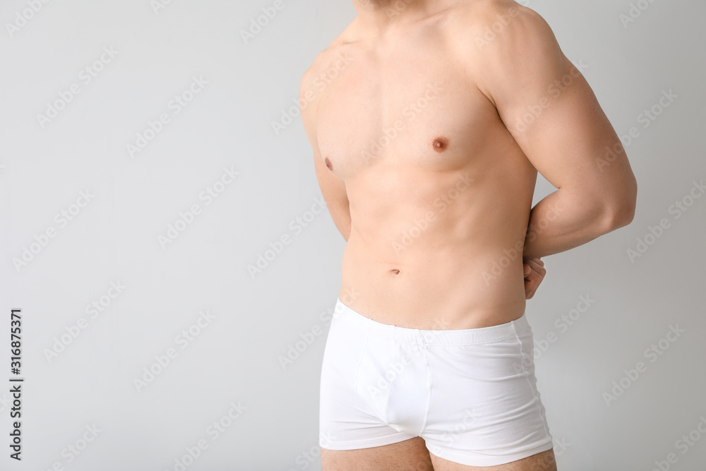 Fototapeta premium Handsome man in underwear on light background
