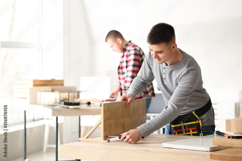 Handyman assembling furniture in workshop Handyman assembling furniture in workshop