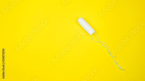 Medical female tampon on ayellow background. Hygienic white tampon for women. Cotton swab. Menstruation, means of protection. Tampons on a red background photo