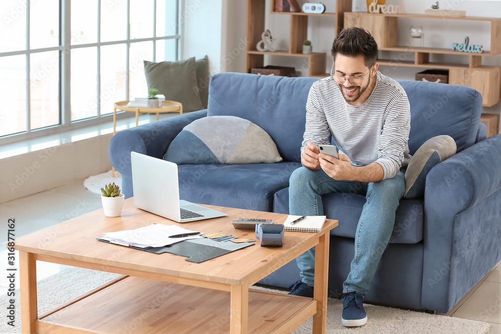 Happy young man with mobile phone at home Happy young man with mobile phone at home