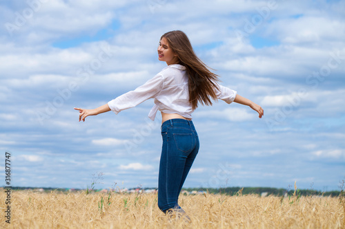 Young brunette woman in white shirt and blue jeans