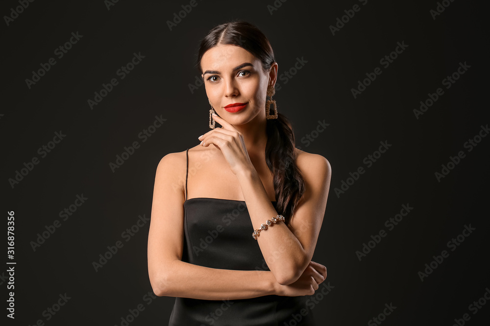 Young woman with beautiful jewelry on dark background Young woman with beautiful jewelry on dark background