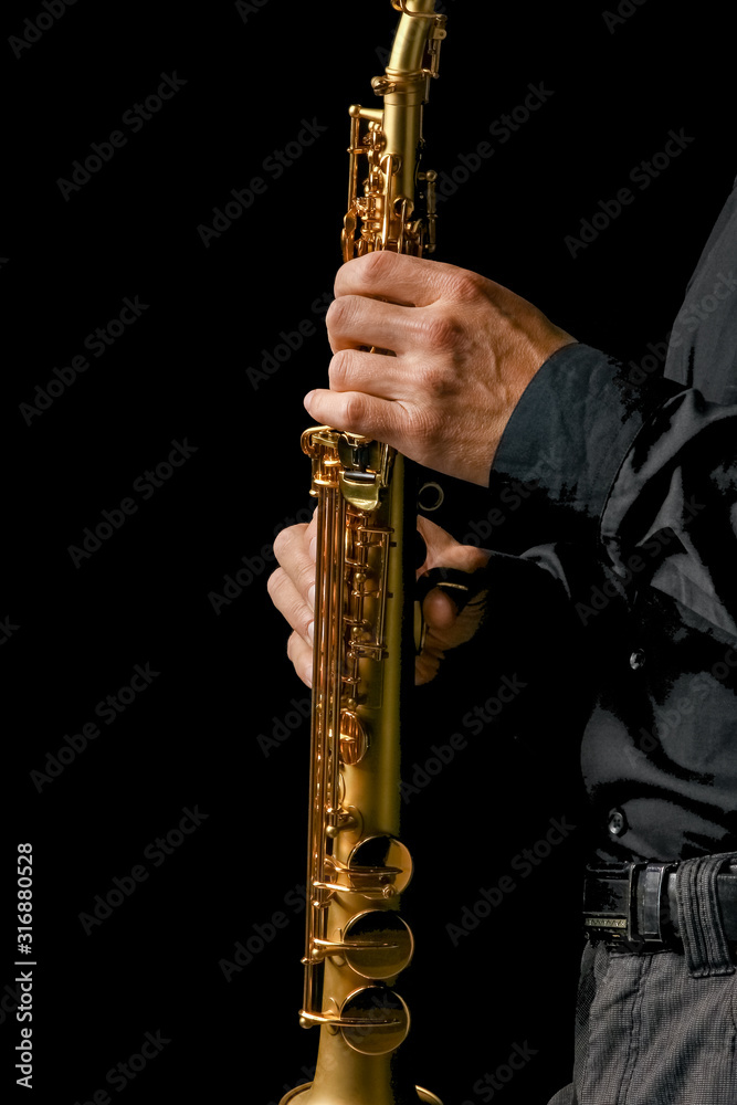 Fototapeta premium soprano saxophone in hands on a black background
