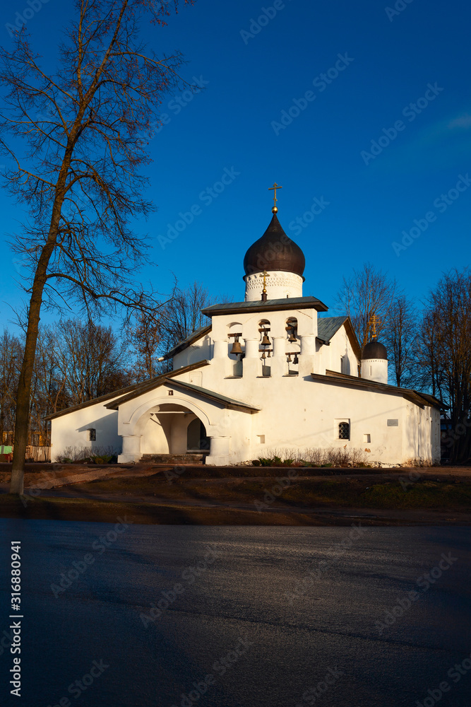 Old church of white color with black domes against the blue sky