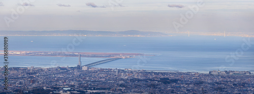 Panoramic view of urban sprawl on edge of Osaka Bay and bridge leading to man-made island photo