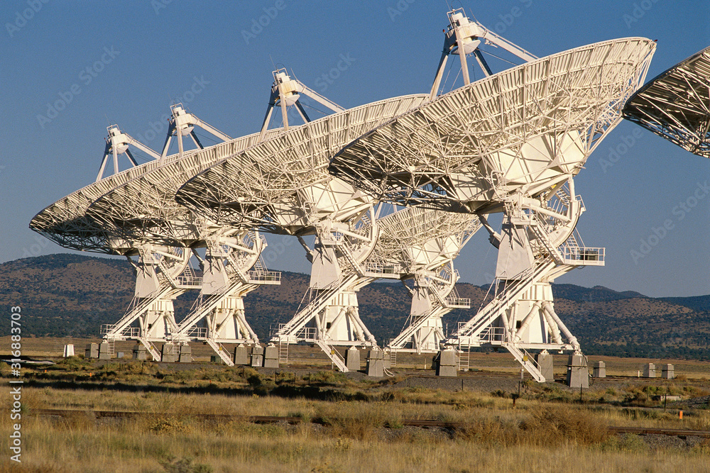 Row of VLA Very Large Array radio telescope dishes facing up