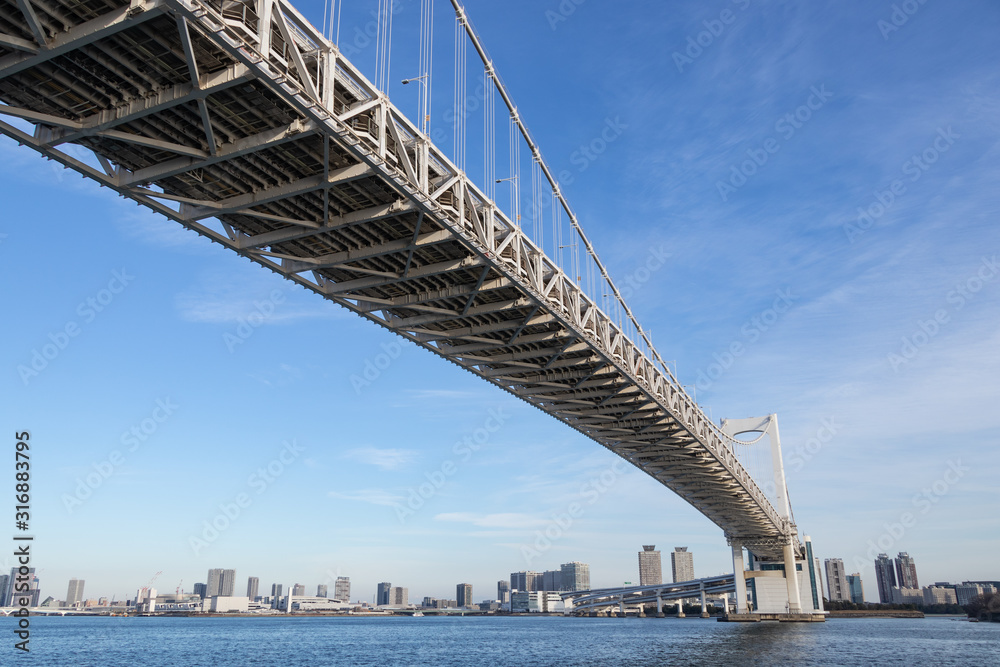 Obraz premium 青空を背景にレインボーブリッジを下から見た景色