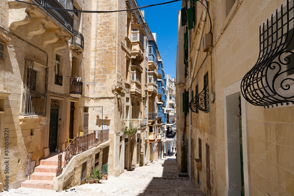 typical narrow street with stairs in the city Valetta on the island of Malta
