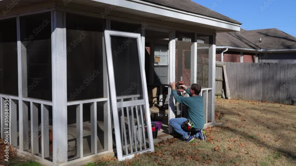 Homeowner works on repairing door to screened in back porch Homeowner works on repairing door to screened in back porch