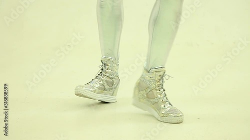  Dancing legs of robot or aloen  girlr. Pretty sexy blonde robot or alien  in silver overalls is dancing. photo