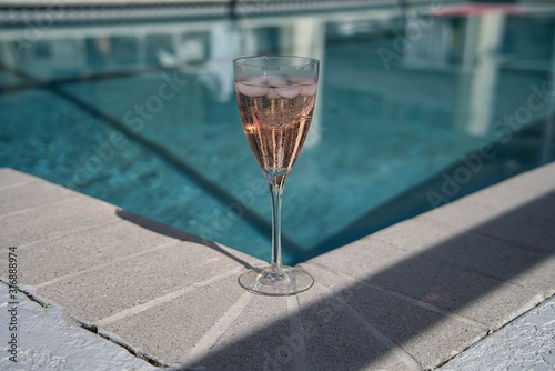 Ein Glas Champagner Prosecco Sekt am Pool mit Bokeh