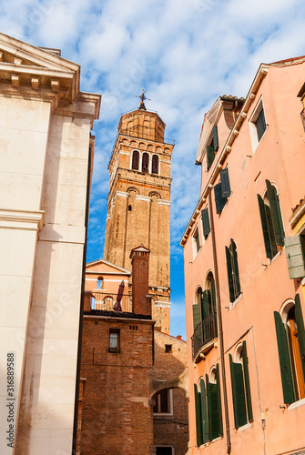 St Stephen Church leaning bell tower rises above old houses in Venice hsitoric center photo