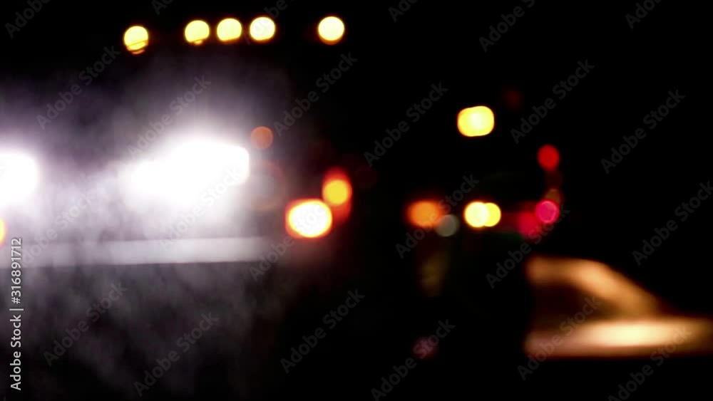 Abstract lights of snow plow truck at night during snowstorm spreading salt going down hill in residential neighborhood Abstract lights of snow plow truck at night during snowstorm spreading salt going down hill in residential neighborhood