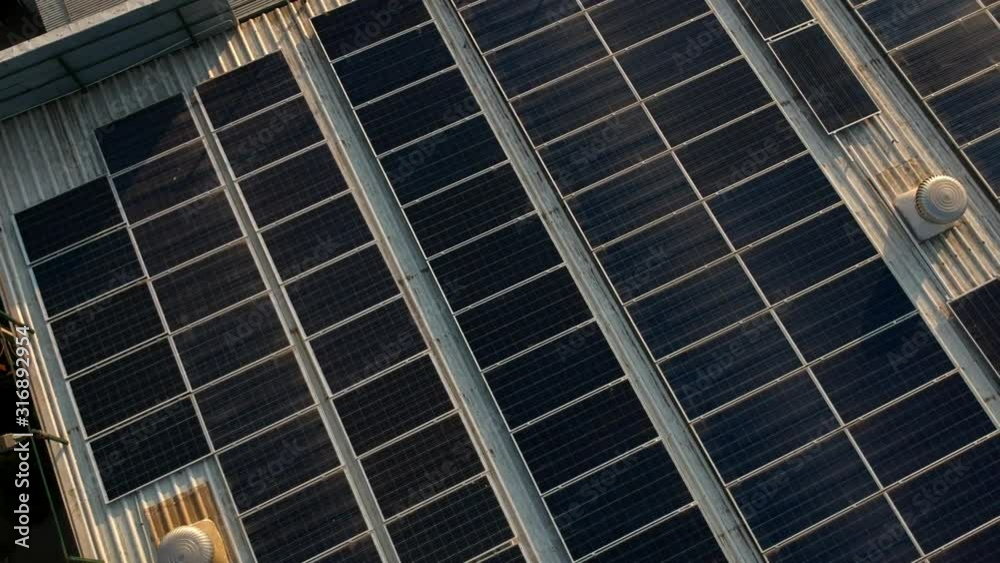 Solar panels on factory roof, shot with drone in evening sunset. Solar panels on factory roof, shot with drone in evening sunset.
