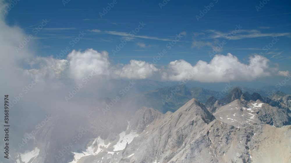 Sharp rocky mountain tops panorama panning view, some clouds and blue sky, big mountain with snow and climbers hiking around. Dolomites, Italy, high quality 4k prores Sharp rocky mountain tops panorama panning view, some clouds and blue sky, big mountain with snow and climbers hiking around. Dolomites, Italy, high quality 4k prores