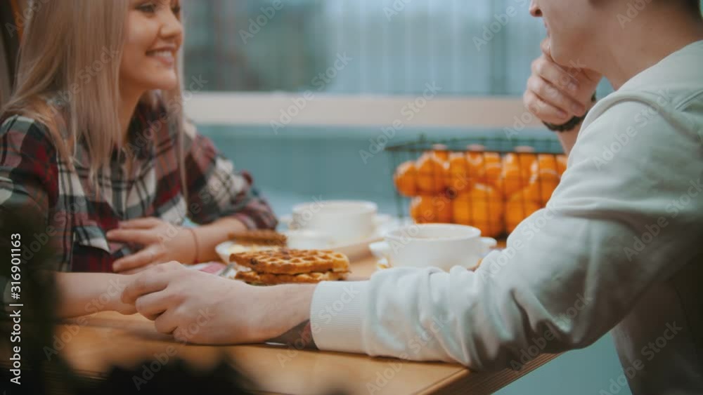 A young couple in cafe having a lunch and talking to each other A young couple in cafe having a lunch and talking to each other