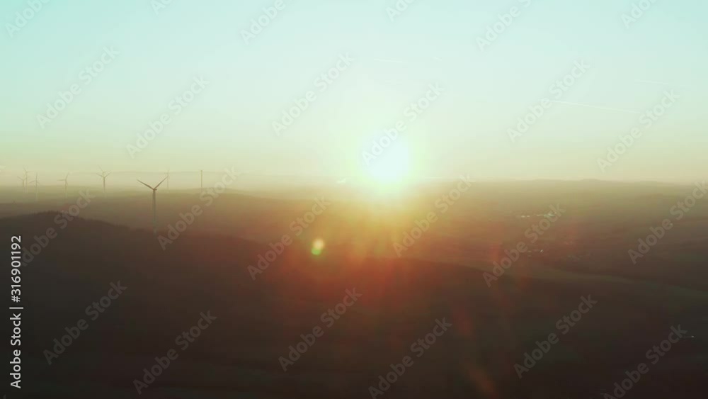 Many wind turbines producing renewable energy in the middle of europe while sunset Many wind turbines producing renewable energy in the middle of europe while sunset
