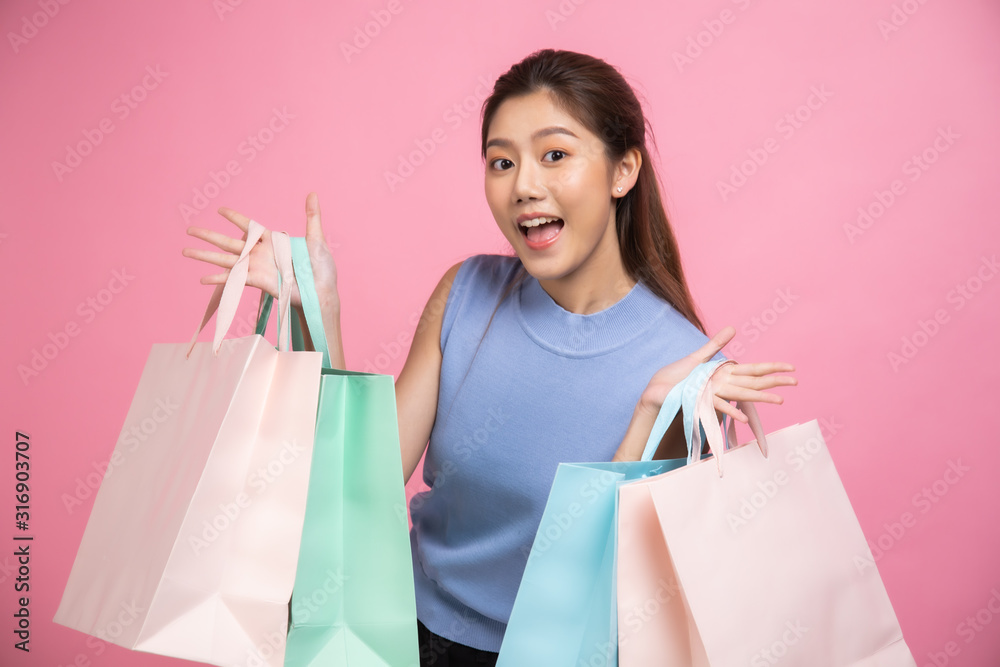 Asian pretty young woman sitting on pink pastel background. She smiling and happy shopping bags. she nice-looking lovely attractive shine She holding mobile. Asian pretty young woman sitting on pink pastel background. She smiling and happy shopping bags. she nice-looking lovely attractive shine She holding mobile.