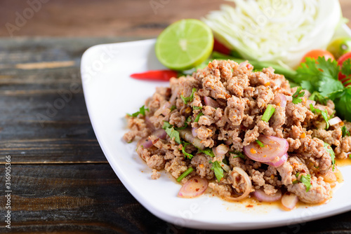 Thai food, spicy minced pork salad (Larb Moo) on white dish photo