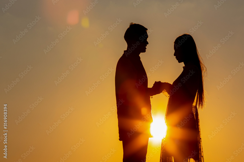 Silhouette of lovers holding hands - hugging together at sunset, love in love Concept: decoration, design, valentine.