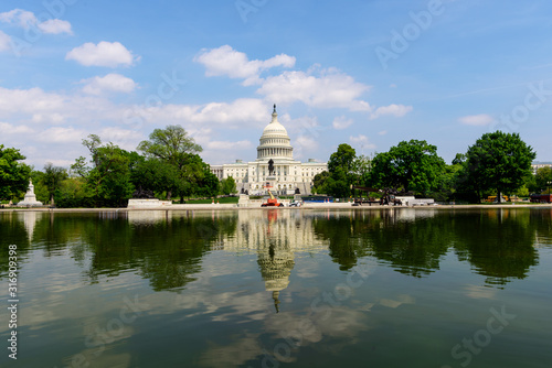 View of Capitol Building with scatter cloud sky in summer, under renovation, Washington DC