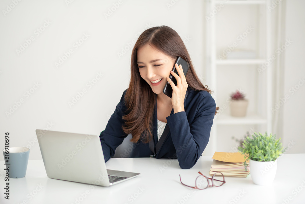 Beautiful Asian businesswoman talking with customer by cell phone. Beautiful Asian businesswoman talking with customer by cell phone.
