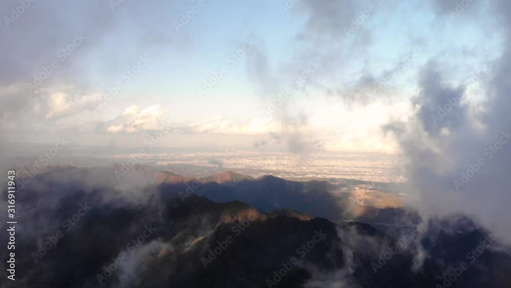 A Heavenly Paradise Of Mountains Covered With White Clouds Underneath A Vibrant Early Morning Sunrise - Aerial Shot
