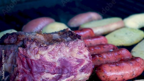 Closeup shot grilled meat with chorizos, cheesetop tortillas, guatemalan beans and grilled potatoes smoking and juicy preparation ready to eat family at a summer season day [HD1920 x 1080] fps 29.97 photo