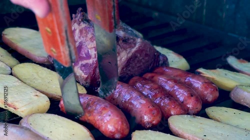 Closeup shot grilled meat with chorizos, cheesetop tortillas, guatemalan beans and grilled potatoes smoking and juicy preparation ready to eat family at a summer season day [HD1920 x 1080] fps 29.97 photo